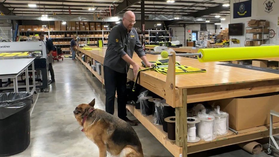 Michael Ratigan looking at a STREP product with his dog, Whistler.